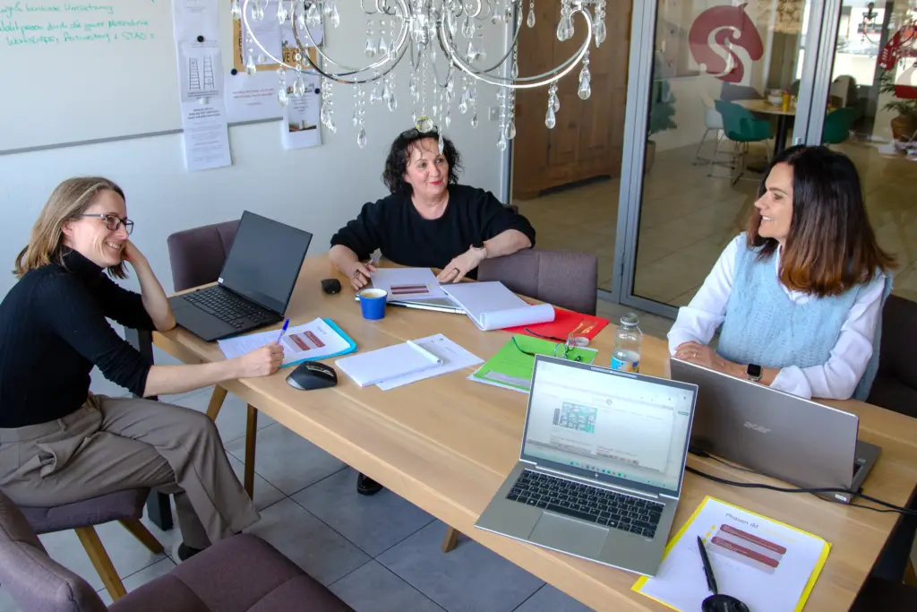 Eine Sitzung bei Sonora Coaching in Düdingen an einem viereckigen Holztisch.